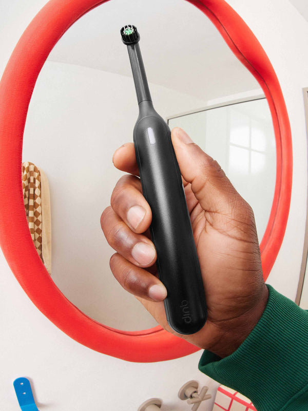 A model holds quip 360 oscillating toothbrush