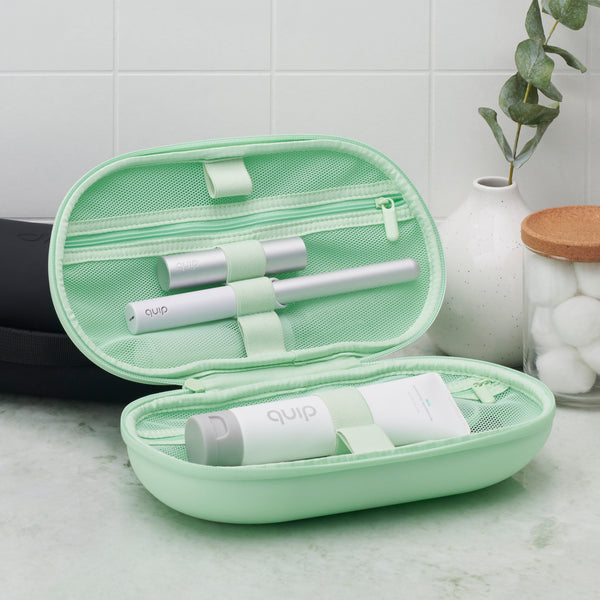 quip refresh bag in color mint, propped up to show it packed and ready for travel with a quip toothpaste and a quip toothbrush securely packed inside.