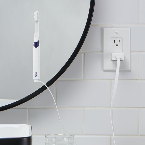 quip Sonic Rechargeable Toothbrush mounted on the bathroom mirror while getting charged