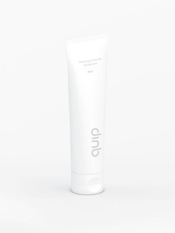 A tube of quip anticavity fluoride toothpaste in mint flavor, standing upright